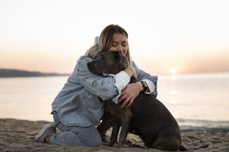 Eine junge Frau umarmt ihren Hund.